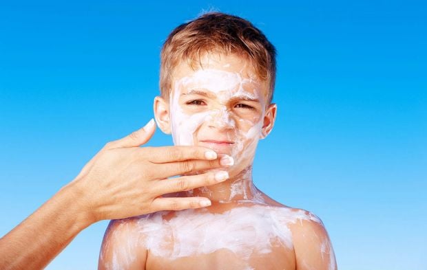 a kid with sunscreen in his body and face