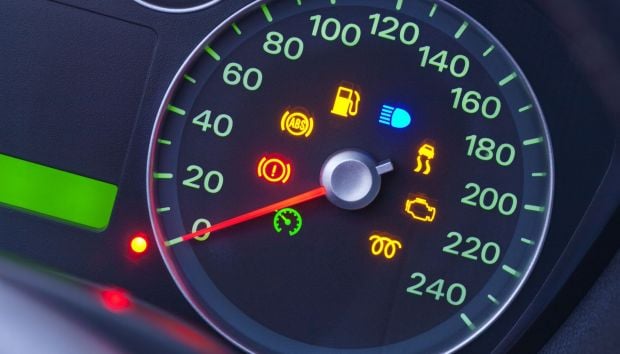 a closeup on the dashboard of a modern car with many warning lights